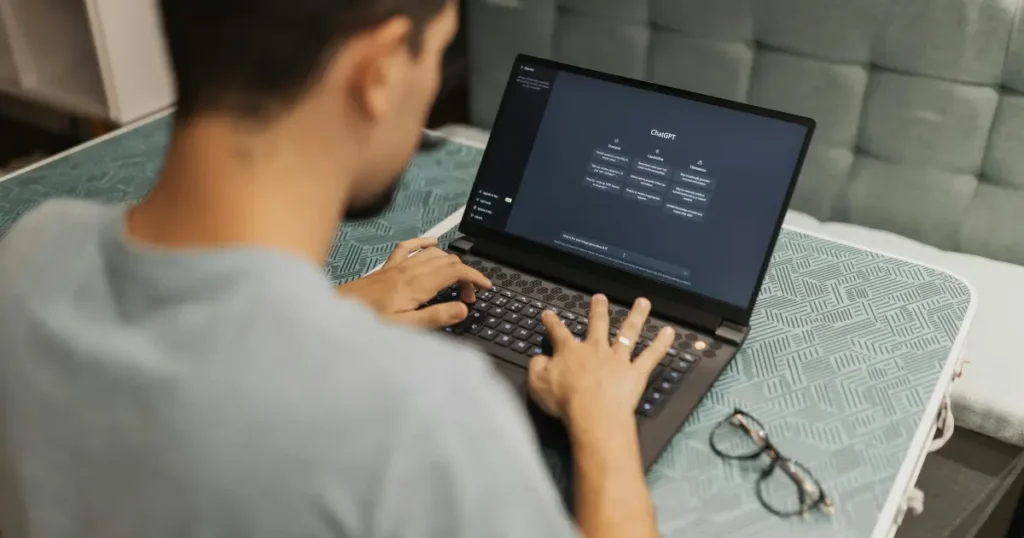 Man using ChatGPT on laptop for AI-powered writing services at home desk